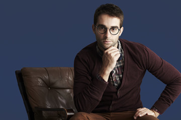 Young thoughtful man against blue background