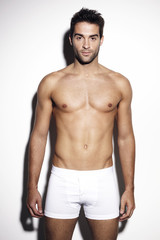 Fototapeta premium Confident young man in white shorts, studio
