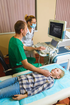 girl getting ultrasound of a thyroid from doctors