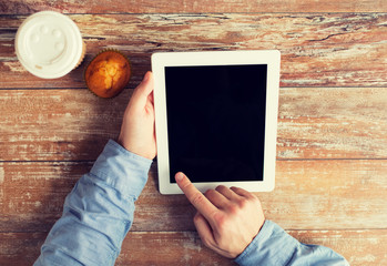 close up of male hands with tablet pc and coffee