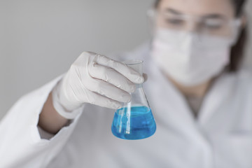 Fototapeta premium close up of woman with flask making test in lab