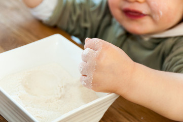 Child's hands playing with the flour
