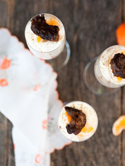 Raw vegan dessert in a glass with cashew nuts and oranges
