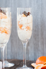 Raw vegan dessert in a glass with cashew nuts and oranges