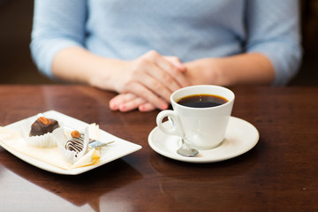 close up of woman hands with coffee and dessert