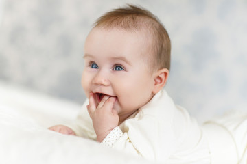 Portrait of a crawling baby on the bed in her room