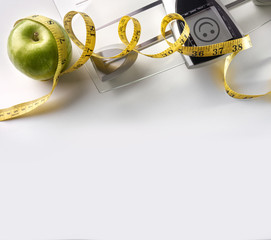 Face scale with apple and tape measure square composition top