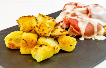 roasted potatoes with ham and cream served  black slate stone  p