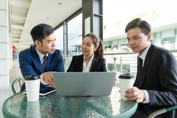 Group of business people discuss project on laptop computer at c