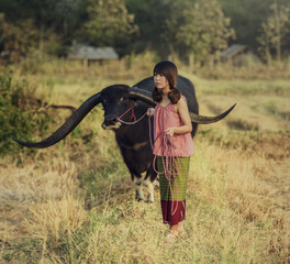 Asian woman listening radio with her buffalo, Thailand (vintage color)