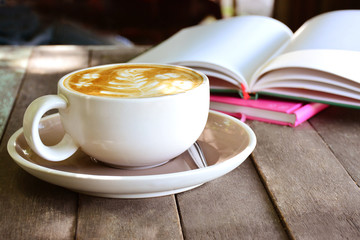 Latte coffee and books on wooden background.