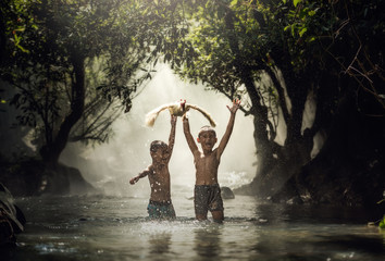 Children catch duck in the creeks, Thailand