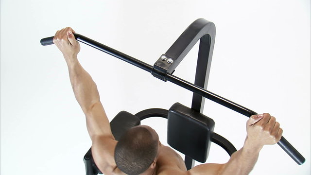 Royalty Free Stock Footage of Jib shot of a man doing pull-ups on a white background.