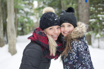 Mother and daughter having fun in the winter park