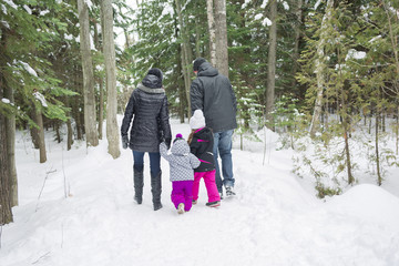Fototapeta na wymiar Happy family walks and playing with snow in winter forest