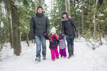 Happy family walks and playing with snow in winter forest