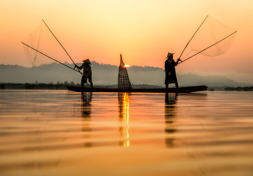 Fisherman in action when fishing in the lake , Thailand