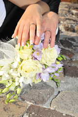 Hands with rings on the flowers- Just married-