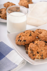 Still life of oatmeal raisin cookies and milk glass