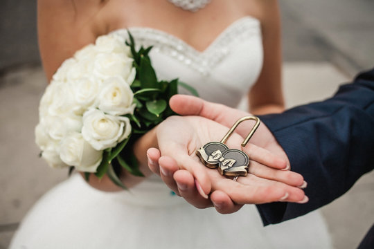 The decorative lock in hands of newlyweds 