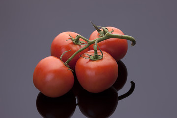 Tomatoes on shiny black background.