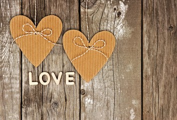 Rustic heart shaped gift tags with LOVE wood letters hanging against a vintage wooden background