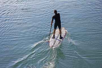 Stand up paddle board man paddleboarding on tranquil lake