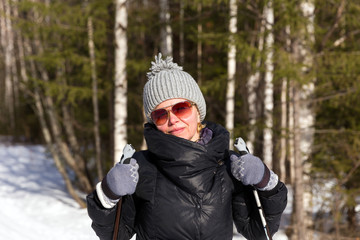 Fototapeta na wymiar Happy young woman skiing in the winter forest
