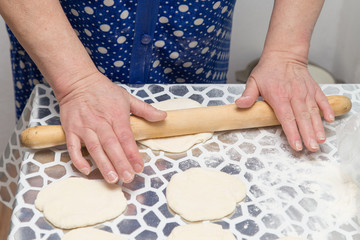 sheeting the dough with a rolling pin in the kitchen