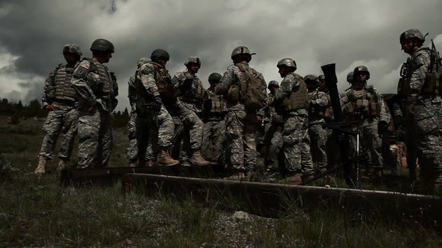 Soldiers receiving instruction at mortar range; panning right.