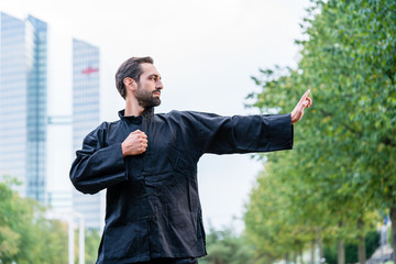 Kampfsportler übt Karate vor Bürogebäude in Stadt