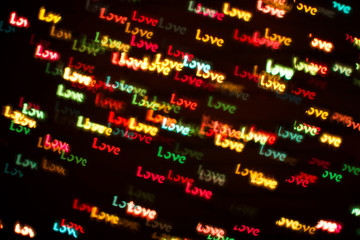 Blurring lights bokeh background of colorful words LOVE