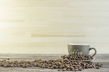 Cup of coffee  with beans standing on a wooden table