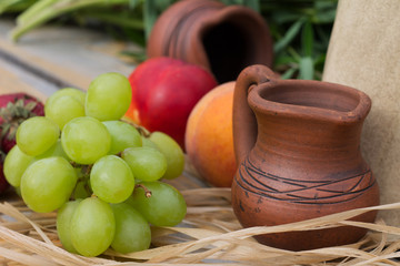 коричневый кувшин, сделанный из глины и гроздь...