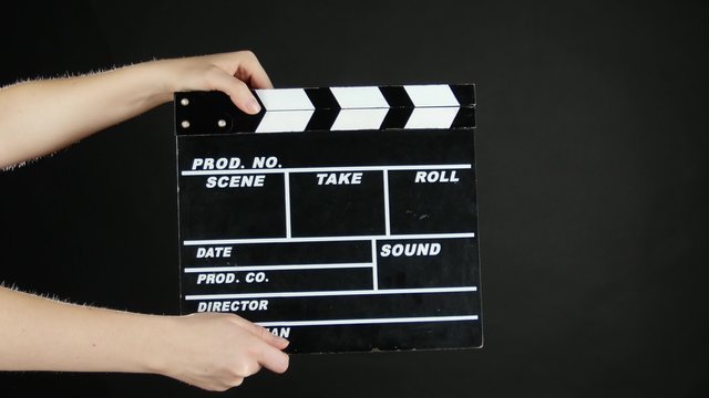 Hands use movie production clapper board, on black