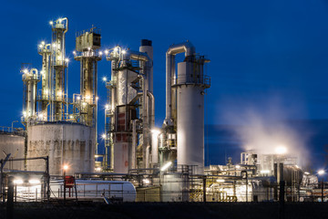 Ölraffinerie mit Rohren, Kolonnen und Lichtern in Speyer in Rheinland-Pfalz bei Nacht	