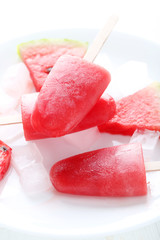 Watermelon popsicle on plate on white wooden table