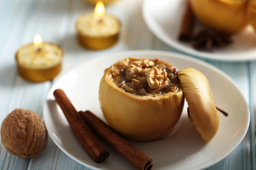 Baked apples on plate on blue wooden table