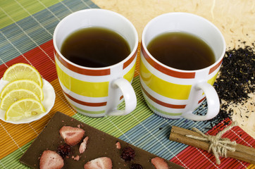 Two cups tea, chocolate, lemon, cinnamon and loose tea.