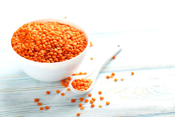Red lentils in bowl on a blue wooden table