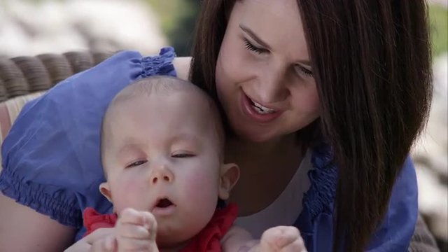 Slow motion of woman playing patty cake with baby girl.