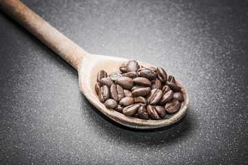 Obraz premium Coffee beans on wooden spoon.