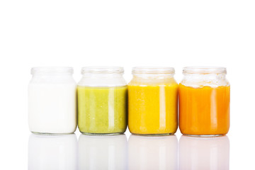 Fototapeta na wymiar Four jars with baby food made of vegetables