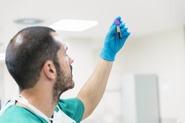 Nurse man holding blood in test tube.