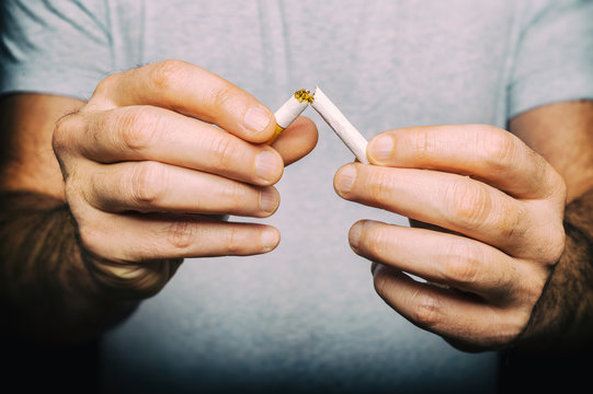 Quitting smoking - male hand crushing cigarette