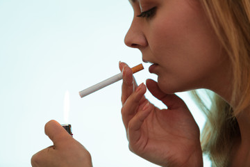 Girl using lighter to light cigarette.
