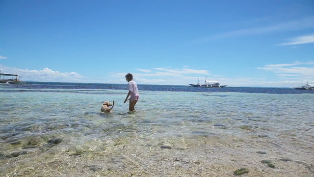 Girl playing with a dog on the beach