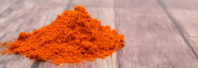 Cayenne pepper powder over wooden background