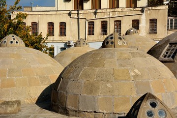 Round ancient roofs of public baths in Baku Old City, within the capital of Azerbaijan, including...