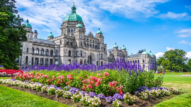 Historic parliament building in Victoria with colorful flowers, BC, Canada